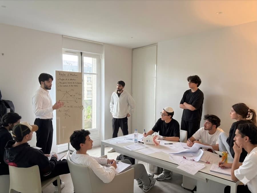 Un professeur expliquant une notion au tableau devant des élèves
